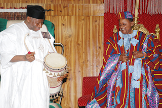 Trying his hands on the talking drum in Oyo