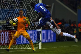 File Photo: Mario Balotelli (C) heads the ball to score a goal as England's goalkeeper Joe Hart (L)