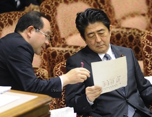 Japanese Prime Minister Shinzo Abe (R) is briefed about the tanker accident