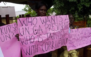 A woman holds a sign as members of the Ugandan activist group ìConcerned citizensî demonstrate outside the US Embassy in Uganda on June 9, 2012.