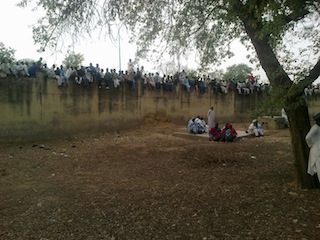 The crowd stand on the wall in a bid to catch a glimpse of Late Ado Bayero