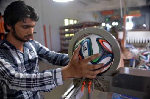 a Pakistani worker checks the Brazuca for accuracy