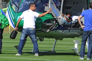 Brazilian striker Neymar lies on a strecher as his father Neymar da Silva Sr (L) waves on