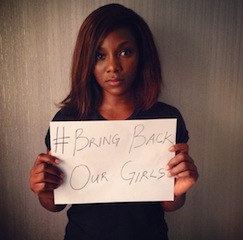 Actress Genevieve Nnaji holds up a poster in support of #BringBackOurGirls