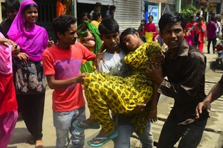 An injured worker is carried by her colleagues as Bangladeshi Police evict striking garment workers from a factory