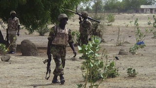 Soldiers walk through Hausari village