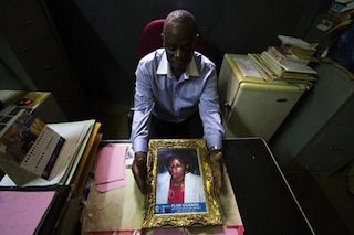 Mr. Wamala holding a picture of his late wife Remie