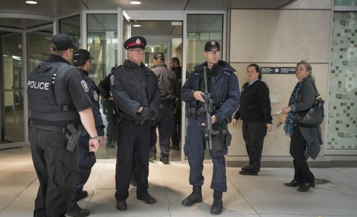 Heavily armed police officers prepare to enter a building on the edge of a restricted zone in Ottawa, Ontario after multiple shootings on October 22, 2014.