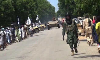 A screengrab taken on November 9, 2014 from a new Boko Haram video released by the Nigerian Islamist extremist group Boko Haram and obtained by AFP shows Boko Haram fighters parading with a tank in an unidentified town