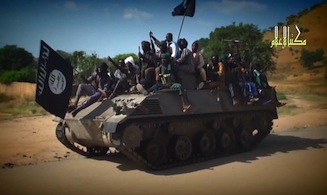 A screengrab taken on November 9, 2014 from a new Boko Haram video released by the Nigerian Islamist extremist group Boko Haram and obtained by AFP shows Boko Haram fighters parading on a tank in an unidentified town. 