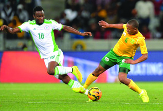 •TACKLE...South African Andile Jali (right) tackles John Mikel Obi of Nigeria during the 2015 AFCON qualifier match between played at Cape Town Stadium on 10 September 10, 2014 in Cape Town, South Africa. The two teams clash again on Wednesday in Uyo, Cross River State.