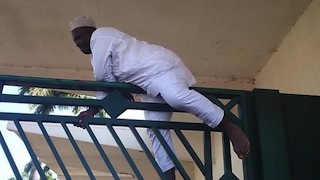 Hon Cheche,  from Niger State,  climbing over NASS gate to enter the premises