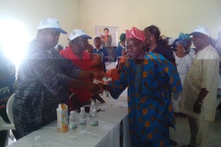 Prince Lanre Tejuoso presenting an ATM card to one of the beneficiaries