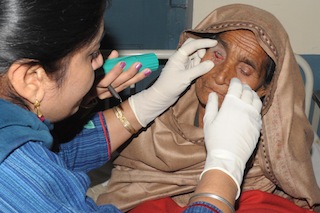 An Indian doctor inspects the eye of a patient