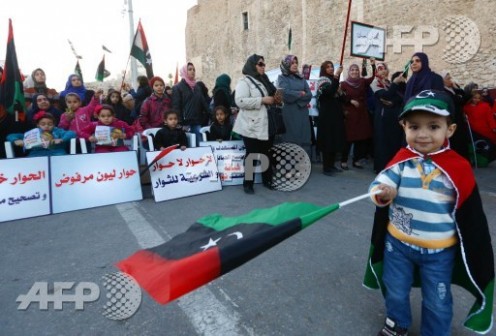A Libyan child waves a national flag during a rally of supporters of "Fajr Libya" (Libya Dawn), a mainly-Islamist alliance, against the dialogue on January 16 ,2015 in Tripoli's central Martyr's Square, as peace talks between the country's warring factions kicked off in Geneva. The North African nation has been gripped by deepening conflict since the overthrow of dictator Moamar Kadhafi in a NATO-backed uprising in 2011, with rival governments and powerful militias 