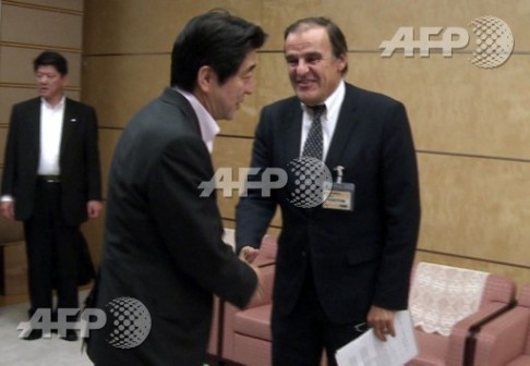 Jacques Lhuillery, right, greets Japan PM Shinzo Abe
