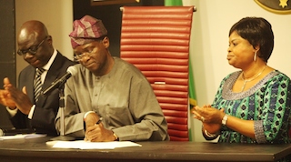 Fashola signing the executive order. He is flanked by deputy governor Adejoke Orelope Adefulire, and Ade Ipaye, Attorney-general