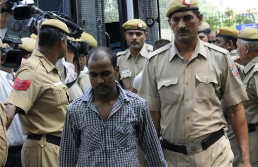Indian police officials escort Mukesh Singh, one of those convicted in the