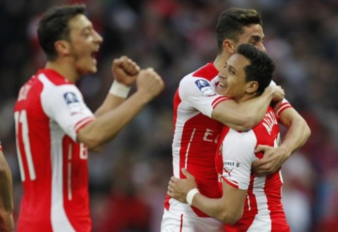 Alexis Sanchez being congratulated by team mates for saving Arsenal