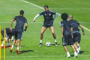 •Cristiano Ronaldo  (middle) shows off his thighs while preparing to perform a trick as his team-mates watch  during a game of keep-ball ahead of the tie against Juventus tonight