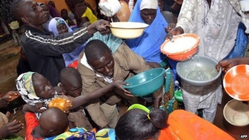 FILE PHOTO: Some children who have been forced out of school by Boko Haram struggle for food at an Internally Displaced Persons camp