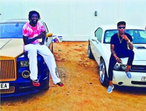 •Adebayor (l) poses with his N79m Rolls Royce Ghost car with Nigerian artiste Wizkid