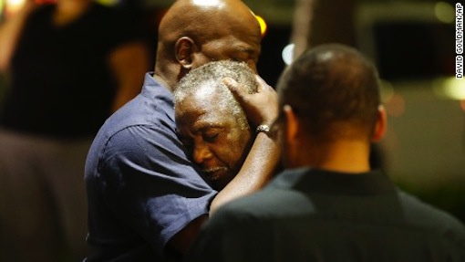 Worshippers embrace following a group prayer across the street from the scene PHOTO: abcnews