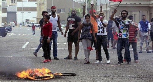 FILE PHOTO: Foreign nationals gesture after clashes broke out between a group of locals and police in Durban on April 14 ,2015 in violence against foreign nationals in Durban, South Africa.  AFP PHOTO/PHOTO STRINGER