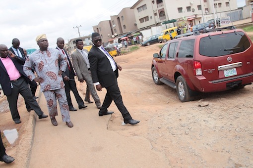 Lagos State Governor, Mr. Akinwunmi Ambode (left) having a close view during his inspection of Ikotun-Ejigbo-Isolo roads on Tuesday, July 14, 2015
