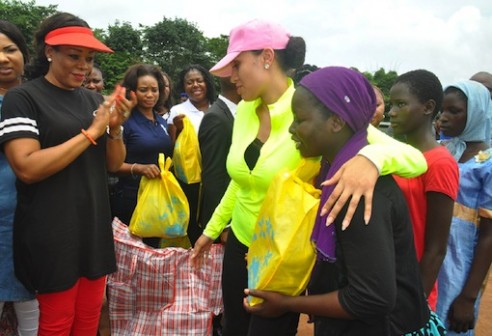 Mrs Iara Oshiomhole, wife of Edo State Governor, presents some items to Internally Displaced Persons at the IDP Camp.