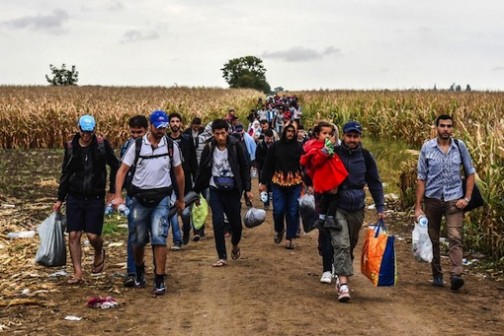 Migrants walk on a dirt road towards the Serbia-Croatia border, near the western-Serbia town of Sid, on September 20, 2015 (AFP Photo/Armend Nimani)
