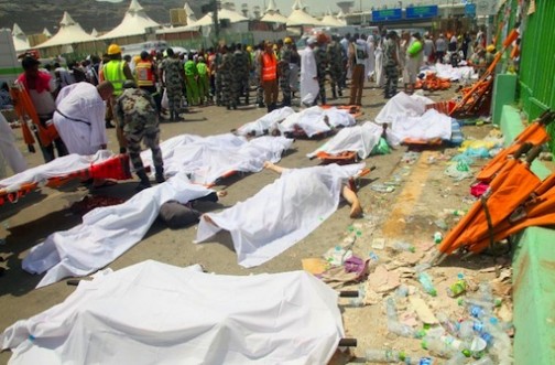 Saudi emergency personnel and Hajj pilgrims stand near bodies covered in sheets where at least 450 were killed and hundreds wounded in a stampede in Mina, near the holy city of Mecca, at the annual hajj in Saudi Arabia on September 24, 2015 (AFP Photo/)