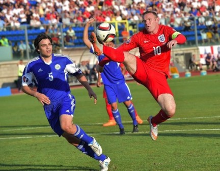 FILE PHOTO: England forward Wayne Rooney (R) and San Marino defender Davide Simoncini during their Euro qualifying match in Serravalle on September 5, 2015 (AFP Photo/Vincenzo Pinto)