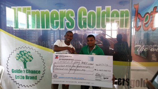 General Manager of Winners Golden Bet, Mr. Ayodele Sajimi (left) presents a cheque of N6,480,900 to Chigozie Ubaka Prince after winning on the coupon of the company