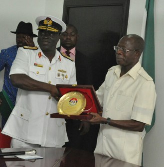 Rear Admiral Samuel Alade, Commandant, Natiional Defence College (left) presents a souvenir to Governor Adams Oshiomhole  Photo: Jethro Ibileke