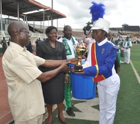 Governor Adams Oshiomhole of Edo State presents the 2nd prize trophy to a student of University Preparatory Secondary School, Benin City at the March pass to mark Nigeria’s 55th Independence Anniversary, Benin City, on Thursday.