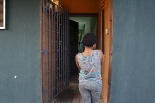 In this photo taken Saturday Aug. 22, 2015. Omo, a former victim of trafficking, stands outside the door of Bakhita Villa, a shelter for trafficking survivors  in Lagos, Nigeria. Nigeria, Africa's most populous country with 170 million people, is a regional hub for human trafficking, and more assistance is needed to help those who escape the exploitation to find a stable place back in Nigeria, say experts who work with survivors. Nigeria tops the list of non-EU citizens registered as trafficking victims, according to the European Commission's 2015 Eurostat report. (AP Photo/Caelainn Hogan)