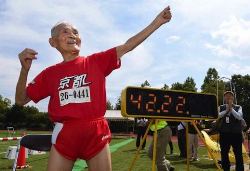 Hidekichi Miyazaki strikes his 'Golden Bolt' pose after the race.  (AFP/Toru Yamanaka)