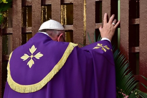 Pope Francis symbolically opens a gate to peace at Bangui Cathedral in the Central African Republic on November 29, 2015, appealing during a landmark mass to warring factions and urging them to "lay down these instruments of death" (AFP Photo/Giuseppe Cacace)