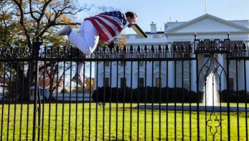 A man climbs a fence at the White House on Thursday, Nov. 26, 2015
