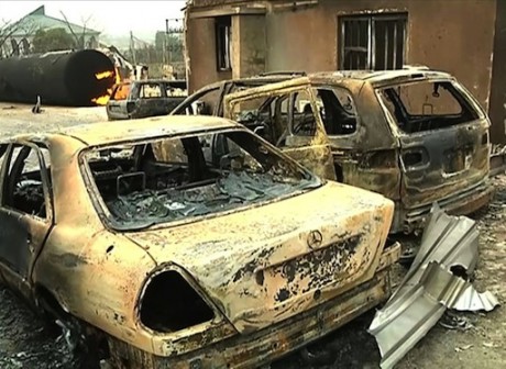 A burning cistern and burnt cars in the aftermath of a blast at an industrial gas plant in Nnewi, southeast Nigeria, in a frame grab made on December 25, 2015 from a video shot the same day by TV Continental
