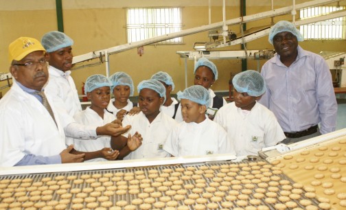 L-R: Mr. Subramanian Murugesan, Managing Director and Mr. Solomon Adekoya, Quality Control Manager of Sona Biscuits taking pupils of Beehive School, Agidingbi, Lagos, through the process of biscuit making at the company's factory in Ota, Ogun State. With them is the school's Vocational Studies teacher, Mr. Stephen Durojaiye.