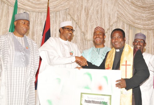 Chairman of the Christian Association of Nigeria (CAN) Abuja Chapter, Pastor Israel Akanji, presenting a Christmas Card on behalf of the Christian community to President Muhammadu Buhari when FCT residents paid a  Christmas Homage   on the President at the Presidential Villa. Others are Senate President Bukola Saraki,  Executive Secretary of Nigerian Pilgrims Commission Mr. Kennedy Opara, and FCT Minister Mohammed Bello.