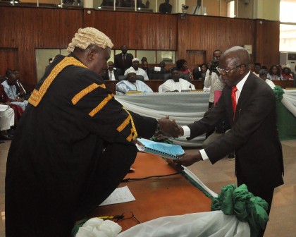 Governor Adams Oshiomhole presenting the state's 2016 Budget to the Clerk of the State House of Assembly.