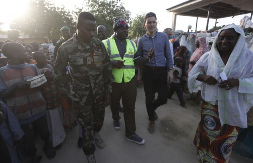 Former UK Foreign Secretary David Miliband, centre right, visits a camp for people displaced by Boko Haram attacks, in Maiduguri, Nigeria, Monday, Dec. 7, 2015.  Miliband, now president of the International Rescue Committee, dropped to kneel to make eye contact with children in the refugee camp that has 1 million residents and 2 million refugees, half of them children. (AP Photo/Sunday Alamba)