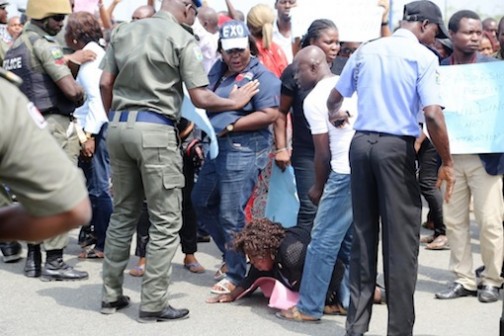 A protester goes to ground as security operatives fend them off Photo: Idowu Ogunleye