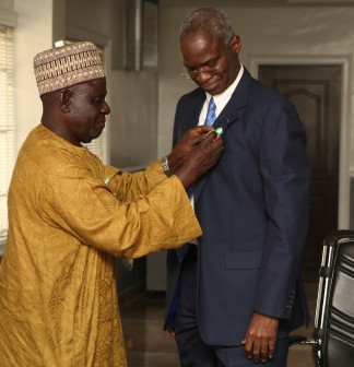 Hon. Minister of Power , Works and Housing , Mr Babatunde Fashola SAN (right) being decorated with the  Armed Forces Remembrance Day Celebration Emblem 2016 by the National Chairman, Nigerian Legion, Colonel Micah Gaya (retd.) at the  Honourable Minister’s Office, Ministry of Work’s Headquarters , Mabushi, Abuja, FCT on Wednesday, December 9, 2015.