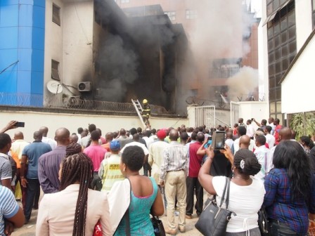 FILE PHOTO: People look on as Samsung showroom/digital centre burns