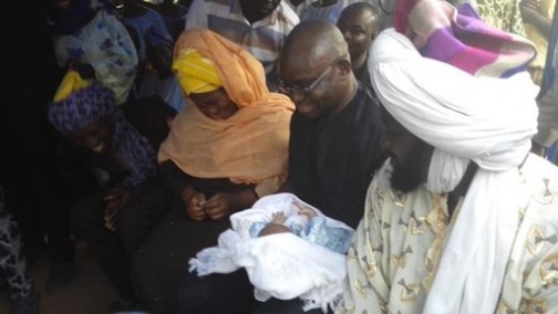 Governor Ayodele Fayose carrying the baby as he celebrates with his family