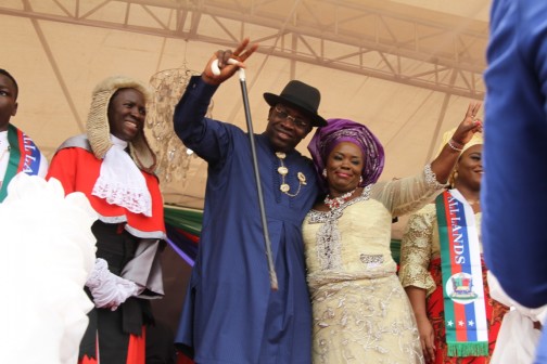 Governor of Bayelsa State, Hon. Seriake Dickson (centre) supported by his wife, Rachael (right) acknowledging cheers from the crowd with the victory sign, shortly after being sworn in for a second term as Governor of Bayelsa State at the Samson Siasia Sports Complex in Yenagoa, while the State Chief Judge, Justice Kate Abiri (left) looks on. Photo by Lucky Francis.